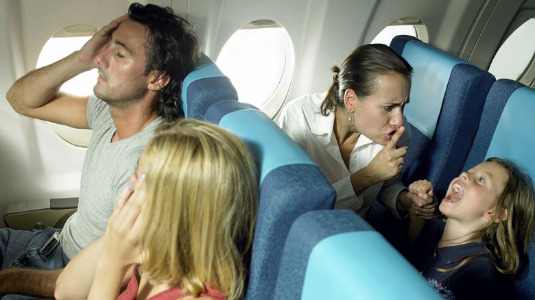 Parent scolding child on plane