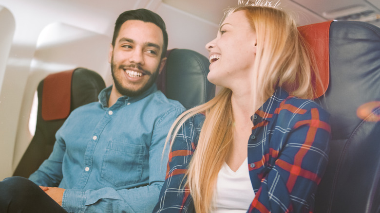 Two smiling passengers having a conversation