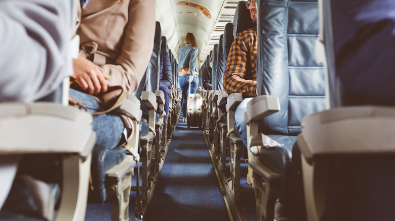 Person walking in a plane aisle