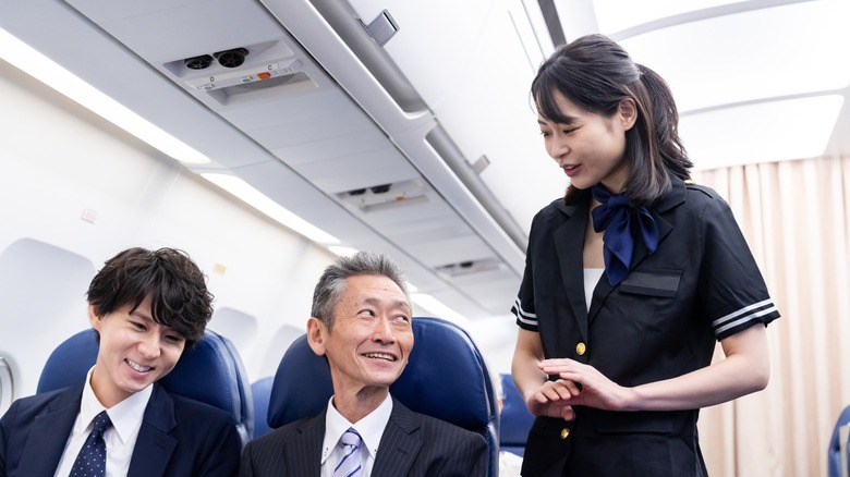 flight attendant with smiling passengers