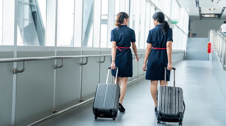 Two flight attendants walking through an airport