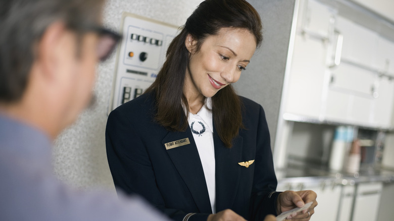 Flight attendant helping passenger