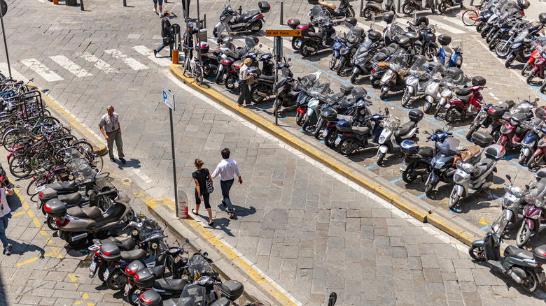 A street in Florence, Italy, with multiple parked Vespas