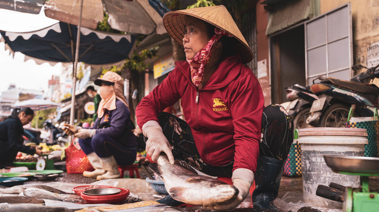 An old woman selling fish on the streets of Ho Chi Minh, Vietnam