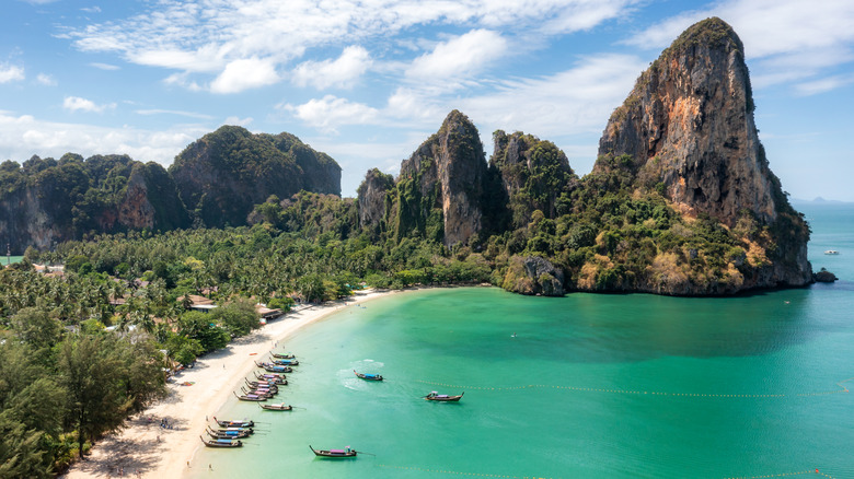 Beach with boats and a resort in Krabi, Thailand