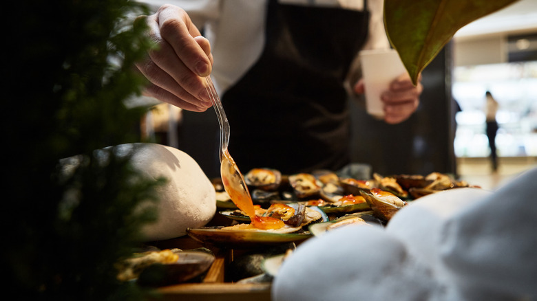 Chef saucing mussels, a staple dish in Nice, France