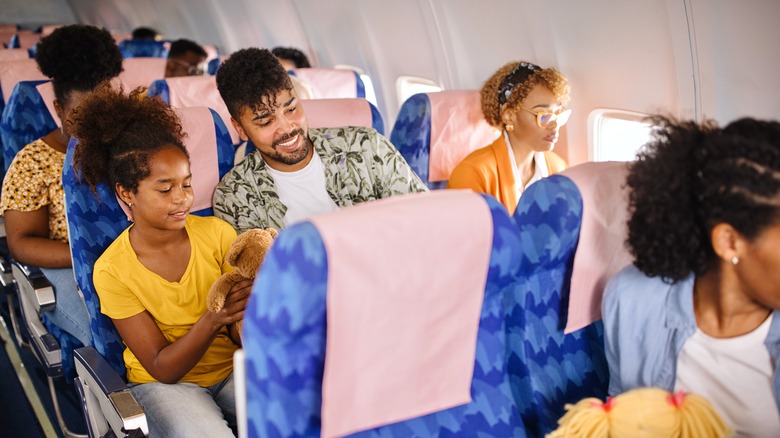 Girl in aisle seat with family