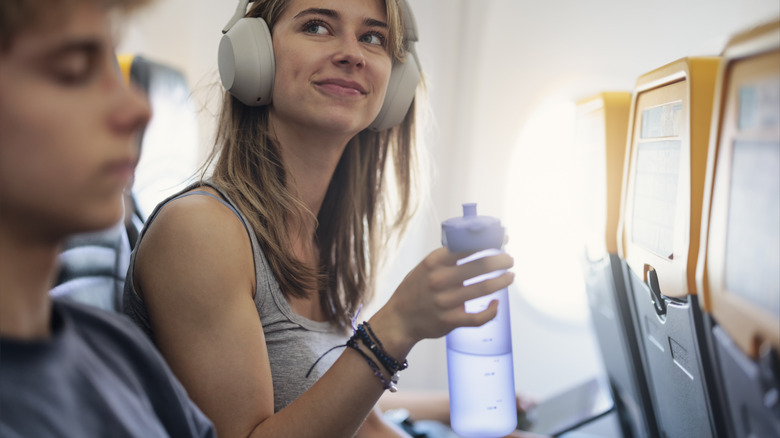 Woman drinking water on plane