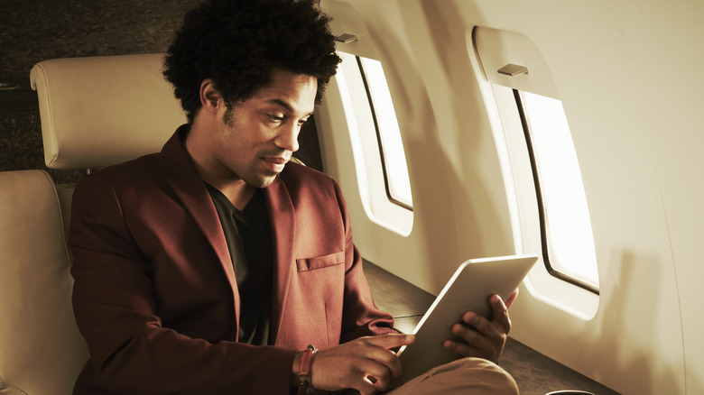 Man using tablet on plane