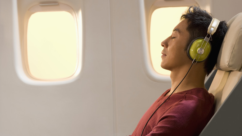 Man with headphones on plane