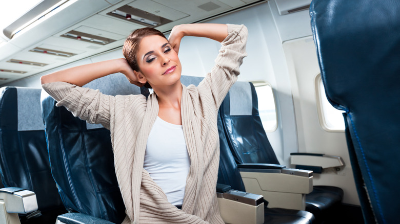 Woman stretching on plane