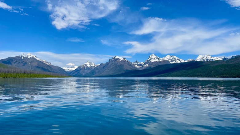 Clear blue Lake McDonald in front of Glacier National Park mountains