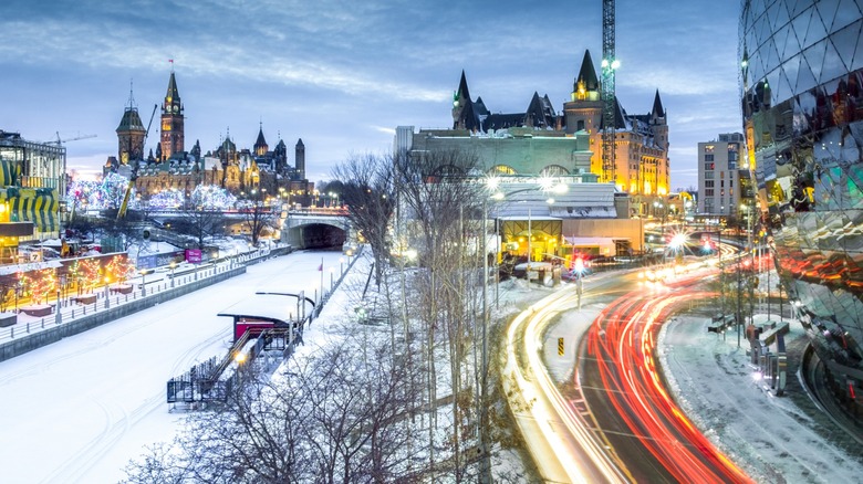 An evening view of the Fairmont Château Laurier hotel, the Parliament building, and the Rideau Canal in Ottawa