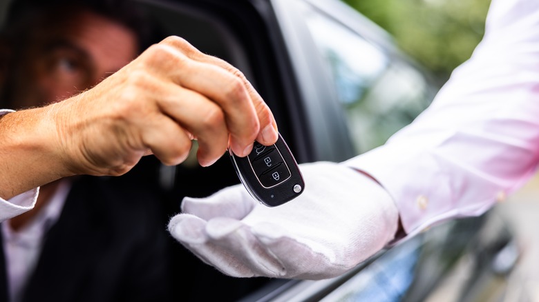 Person giving car keys to valet at hotel