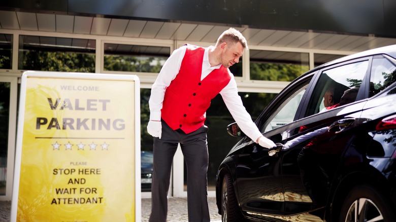 Hotel valet opening car door for client