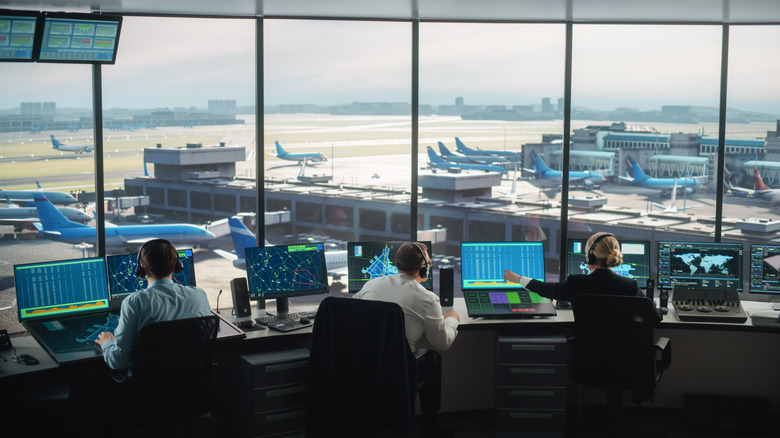 Three air traffic controllers work at busy airport