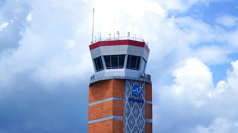 Air traffic control tower against blue cloudy sky