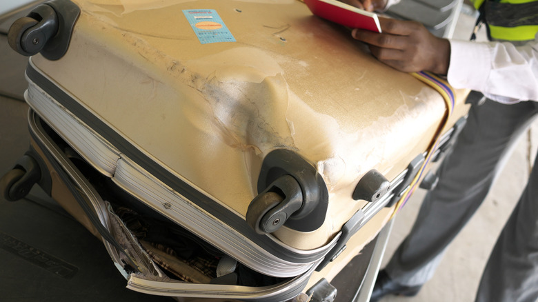 Agent writing a report on damaged luggage