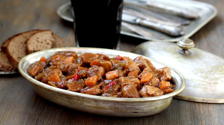 Plate of beef stew with a side of Guinness