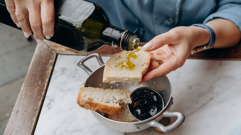 Putting olive oil on bread in Italy