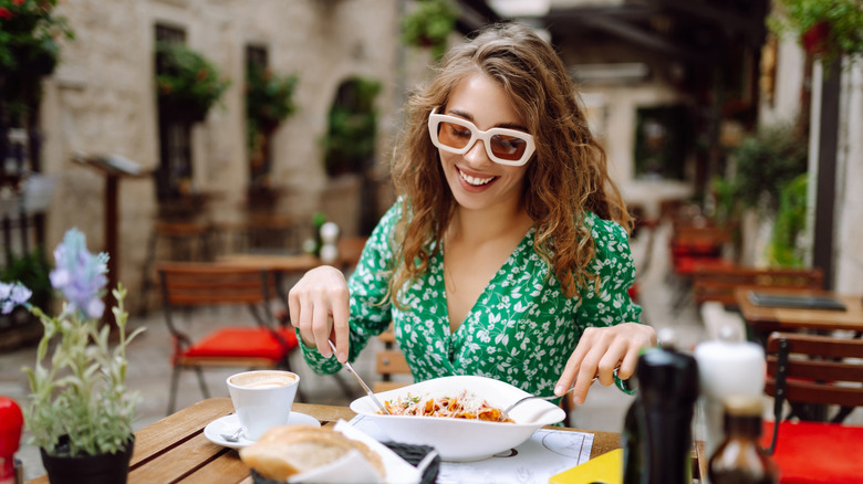 Female tourist tucking into food in Italy