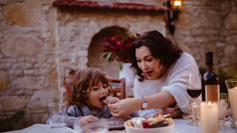 Italian grandmother feeding grandchild some food