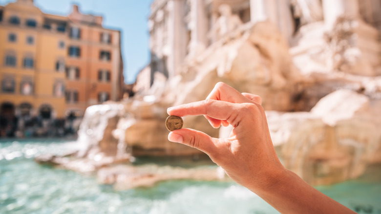 hand holding coin at fountain