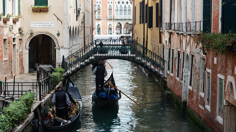 gondoliers on old Italian canal