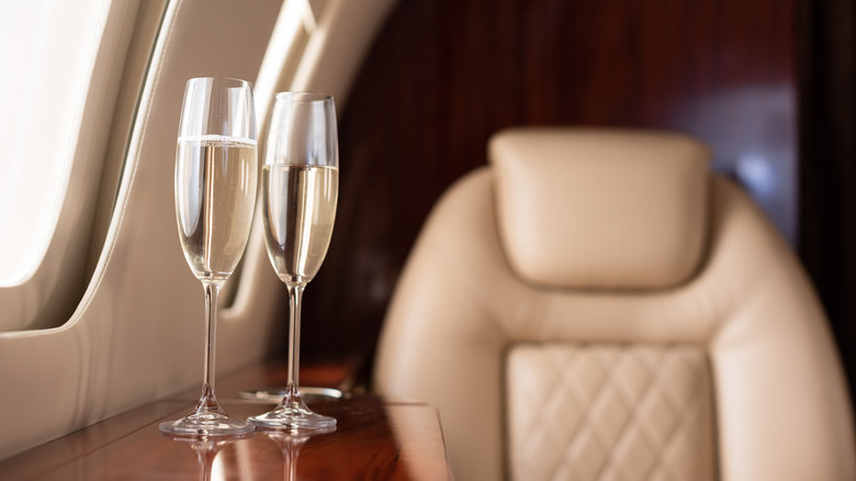 Champagne glasses by a plane window