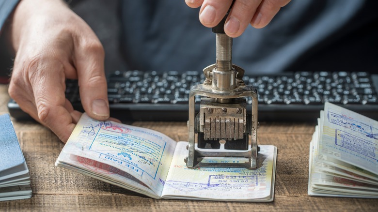 Immigration officer stamping a passport