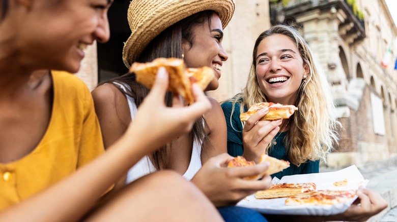 Tourists eating pizza in Italy