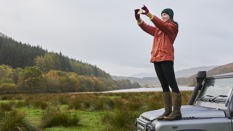 Woman taking picture with phone of outdoors