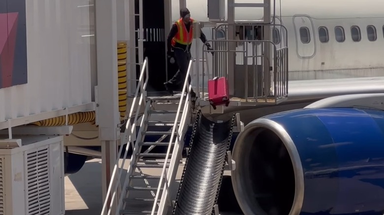 Baggage handler throwing suitcase