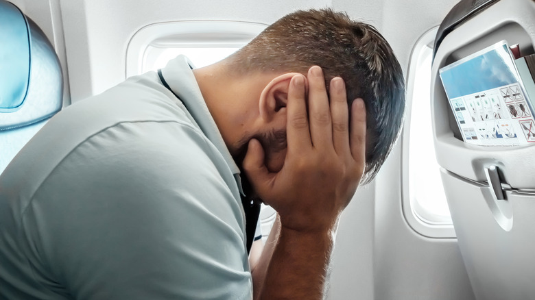 Man with headache on an airplane