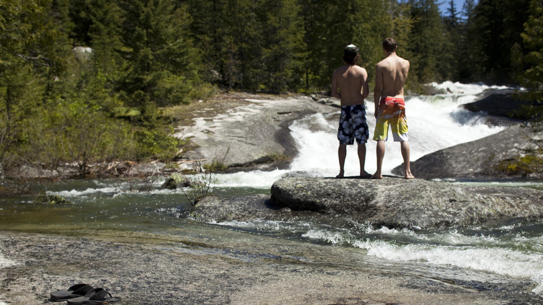 A pair of swimmers stand by a creek in the Idaho Panhandle