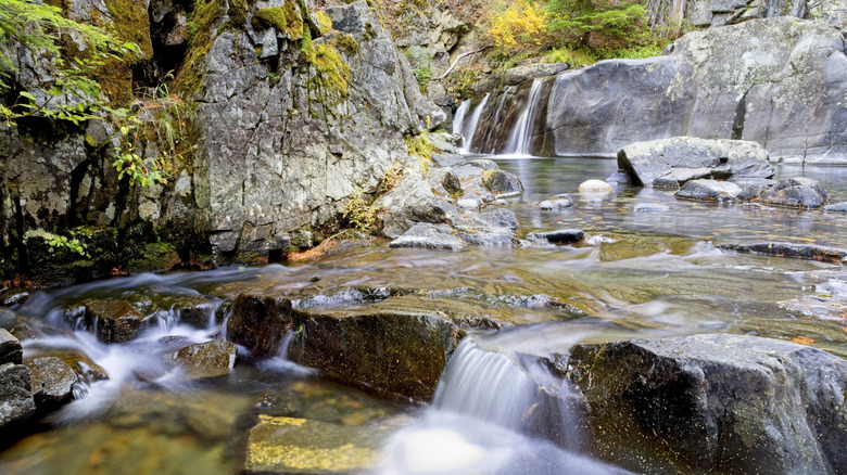 A creek in Idaho with small waterfalls along a rocky landscape