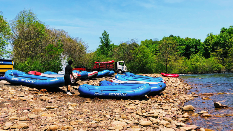 Whitewater rafts parked on a river surrounded by greenery in the Poconos