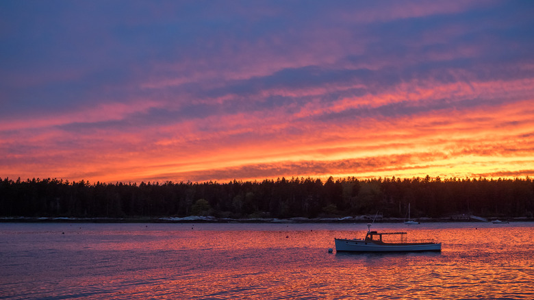 fishing boat on water during sunset