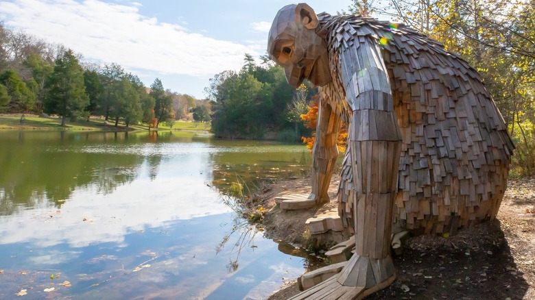 Little Nis sculpture crouching at the water's edge on a clear day