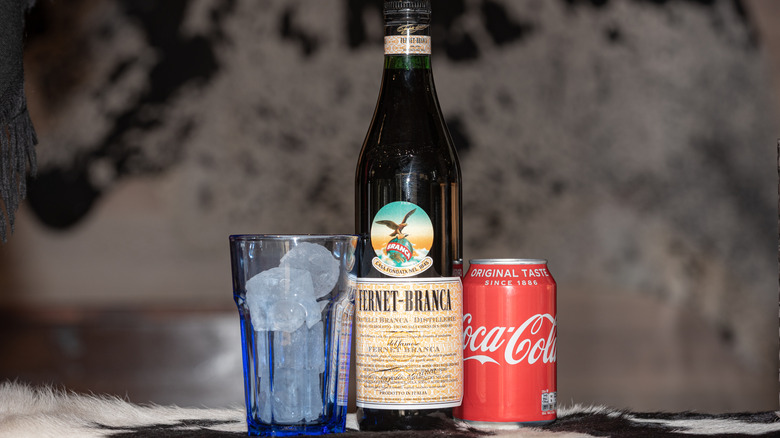 Fernet and Coke next to a glass with ice