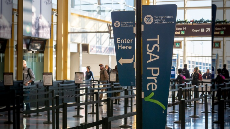 TSA PreCheck sign pointing to special security lane at airport