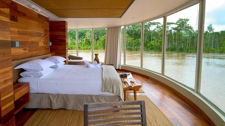 a luxury room with large windows on Delfin Amazon Cruise