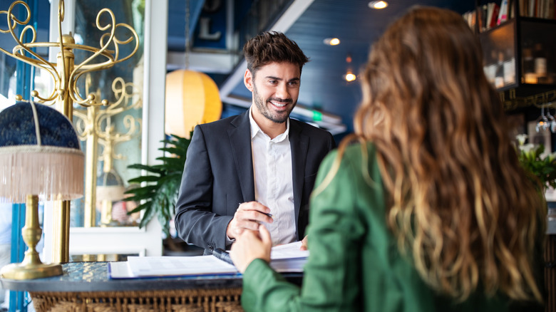 A receptionist helping a guest at check-in