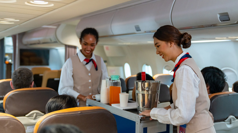 Flight attendants serving drinks on a plane