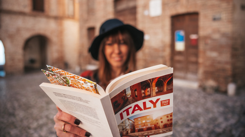 Woman reading Italy guidebook