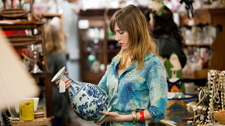 Woman examining a vintage vase