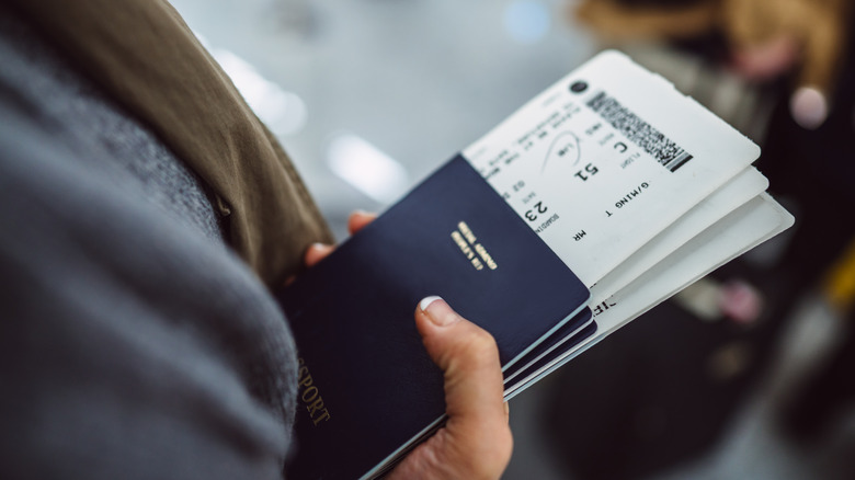 holding passports and boarding passes