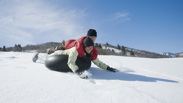 Parent and child tubing in snow