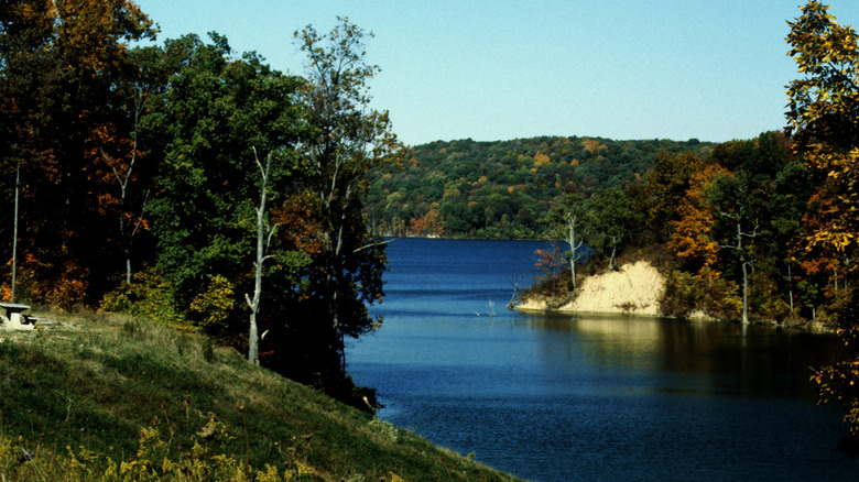 Brookville Lake surrounded by foliage and a picnic bench in Indiana