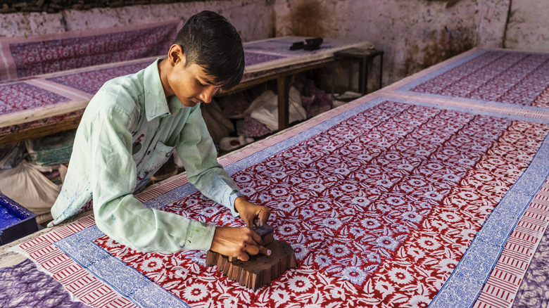 Young man block printing textiles